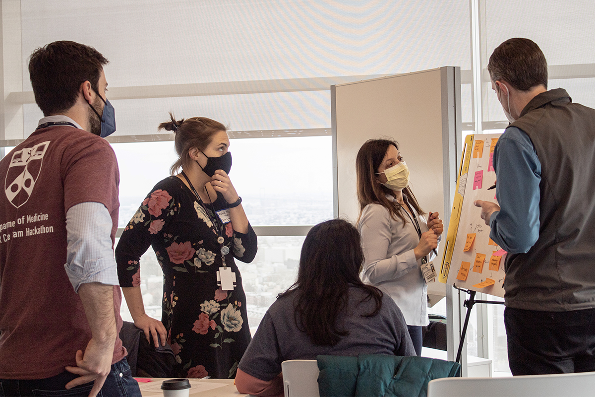 Group discussing near a board covered with sticky notes