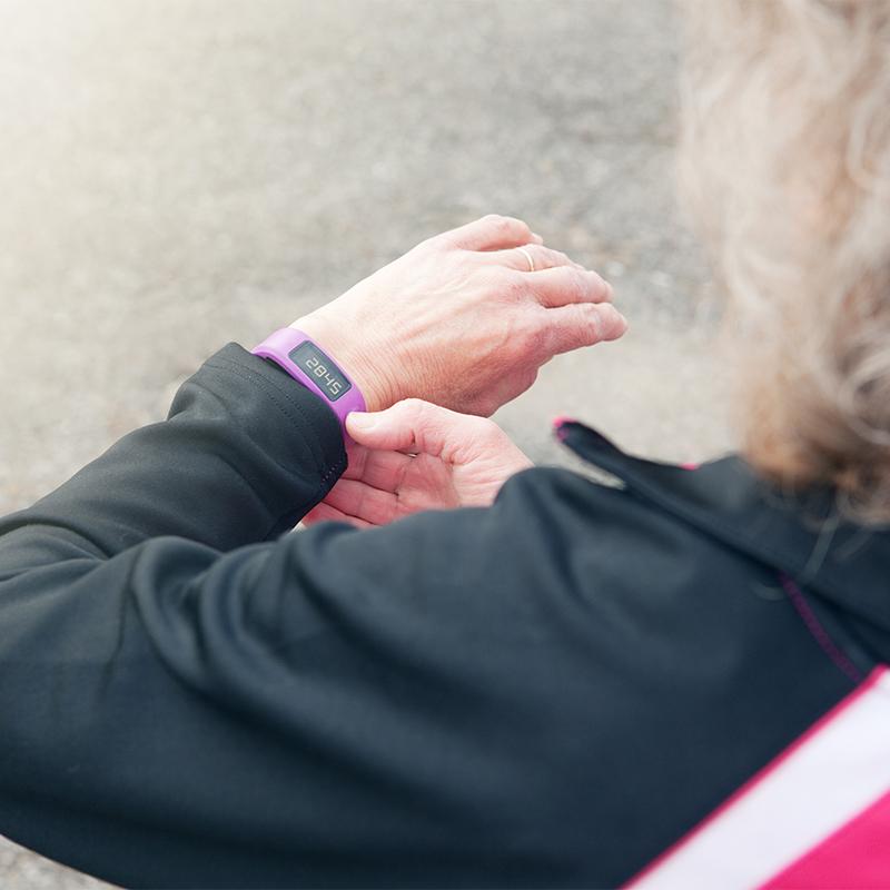 Older woman checks her step count on her wrist watch
