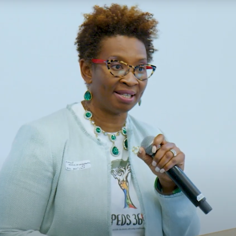 Peds360 spokesperson holding a microphone at the Well City Challenge pitch competition