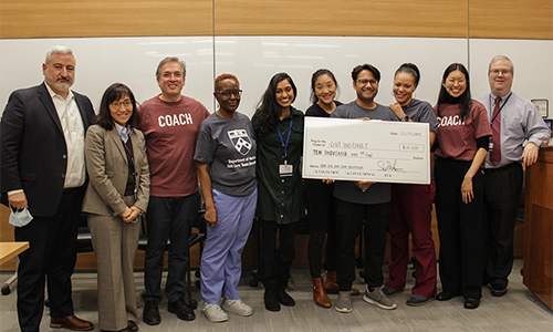 The Gut Instinct team posing with a giant check